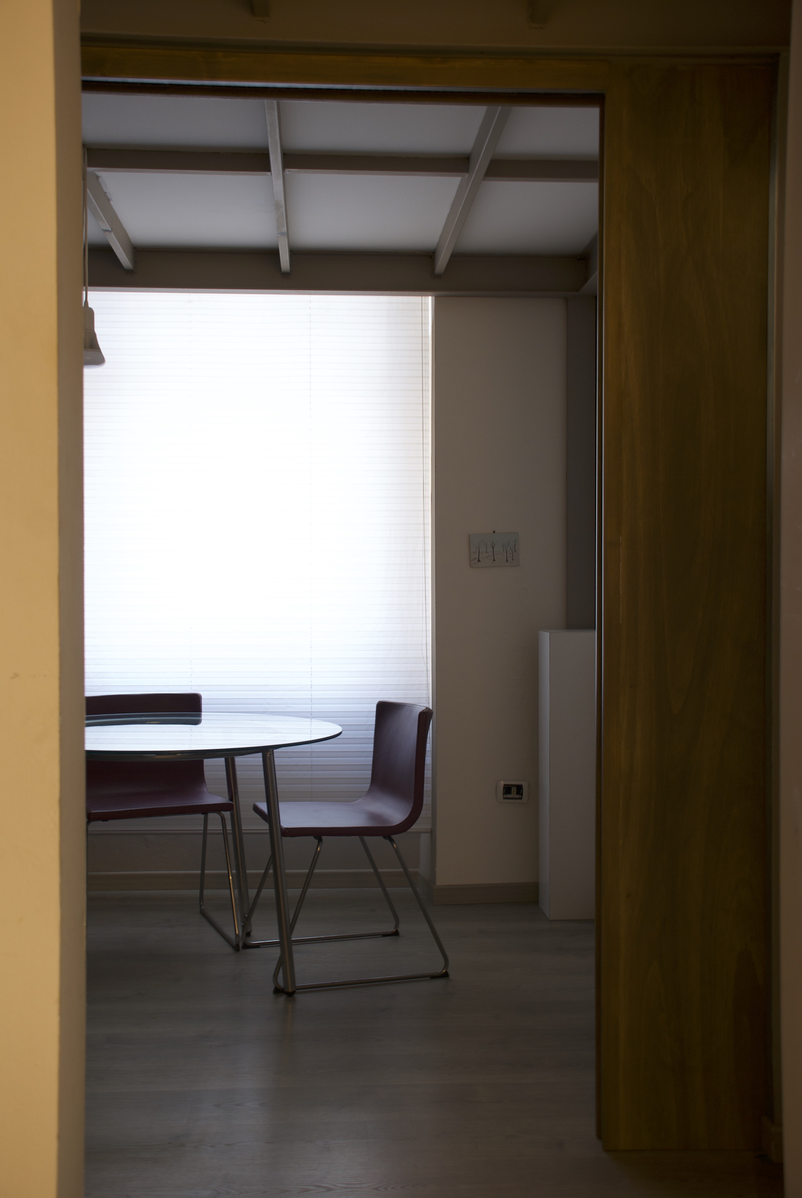 Vista della sala riunioni dello studio attraverso una porta in legno